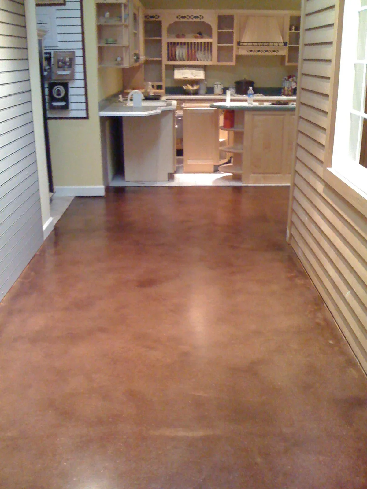 Polished concrete floor in kitchen with glossy brown finish and seamless appearance