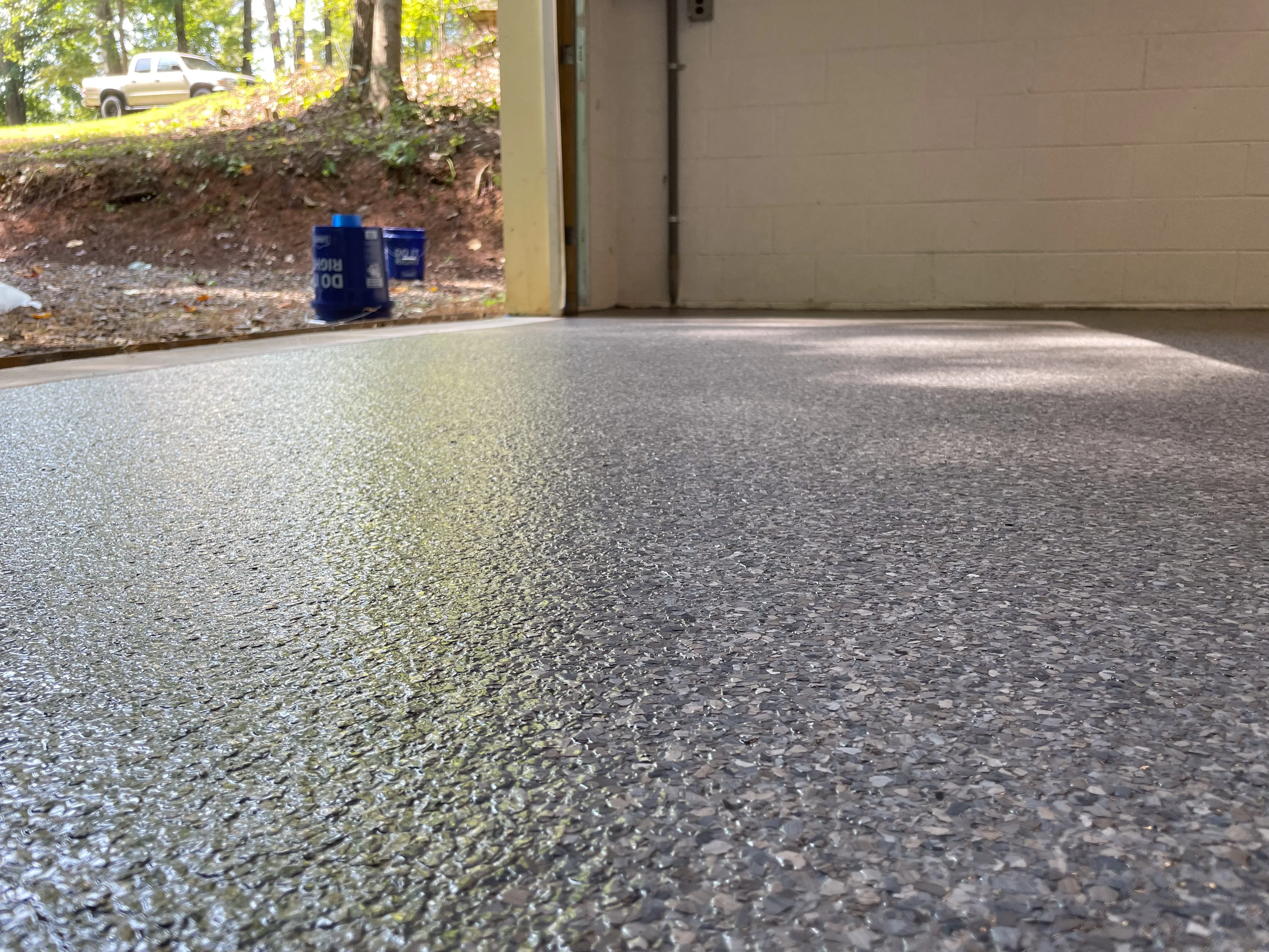 Epoxy-coated garage floor with speckled gray aggregate finish and high-gloss protective coating