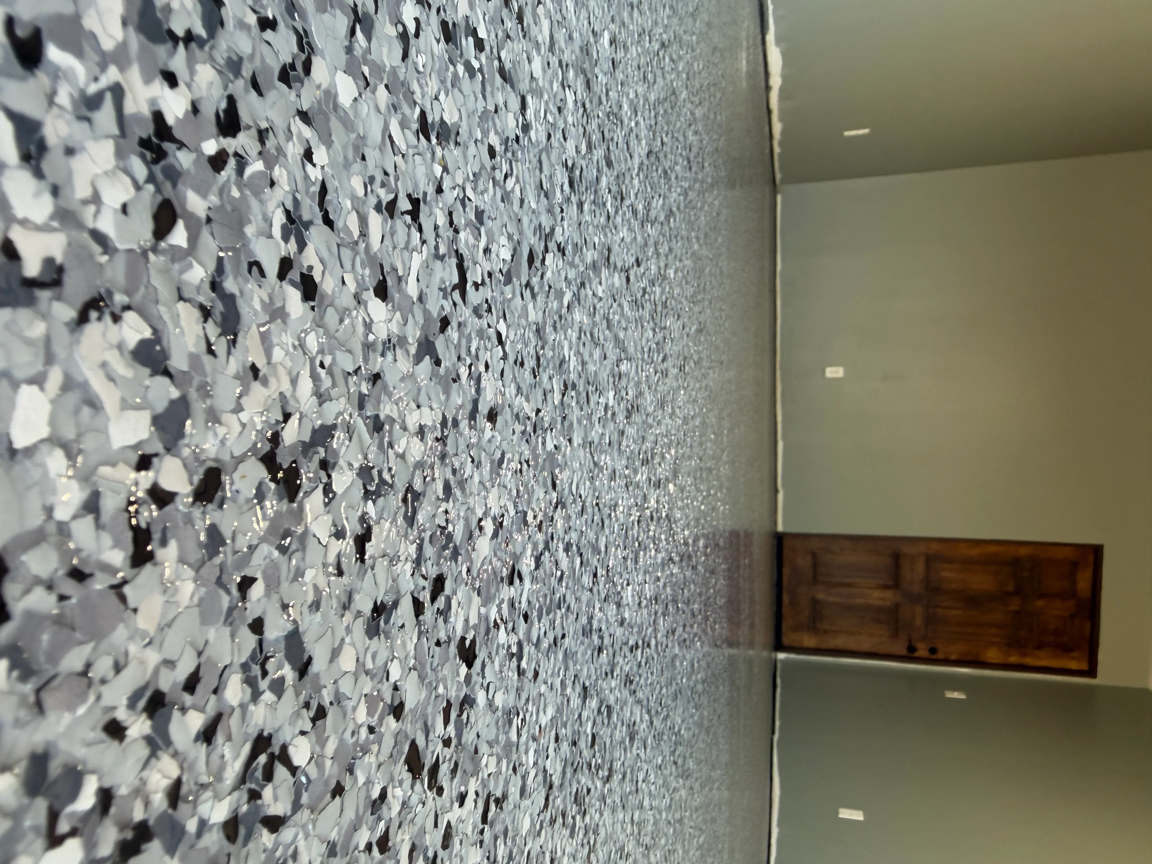White and black decorative flake epoxy coating on concrete floor with seamless finish
