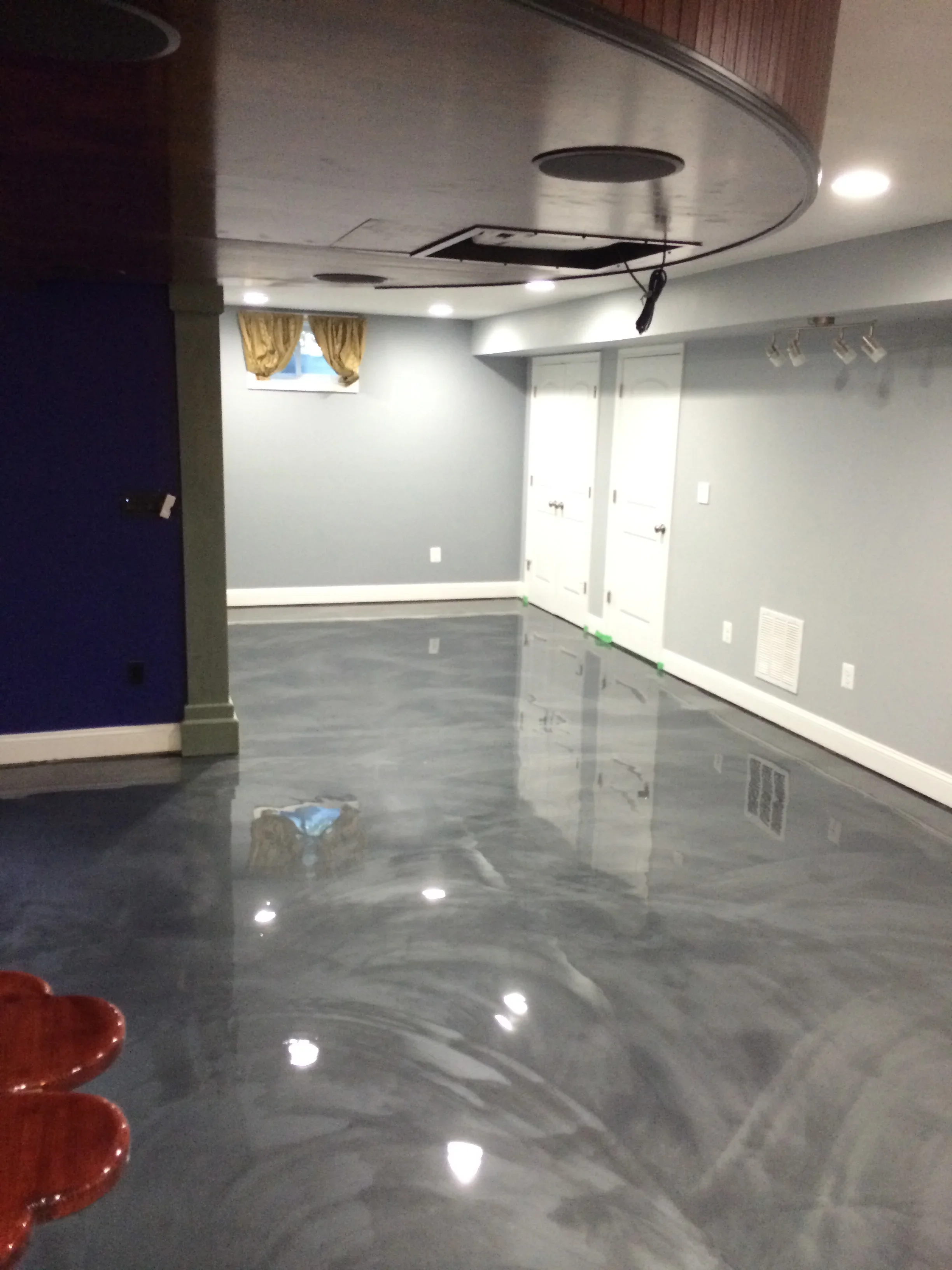 Polished concrete floor with glossy finish in basement with recessed lighting and painted walls