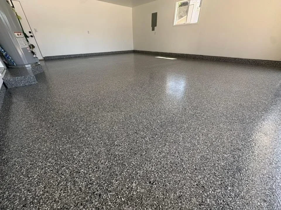 Polished gray epoxy-coated garage floor with speckled aggregate finish and glossy sheen