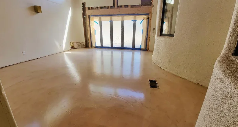 Polished concrete floor with reflective finish in open room with glass doors